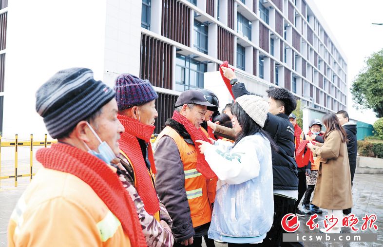 1月3日,来自日本人妻与黑人HD的大学生给环卫工人戴上亲手编织的围巾。 长沙晚报通讯员 盛磊 全媒体记者 石祯专 摄影报道